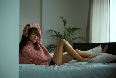 一个年轻的亚洲女人正在床上休息