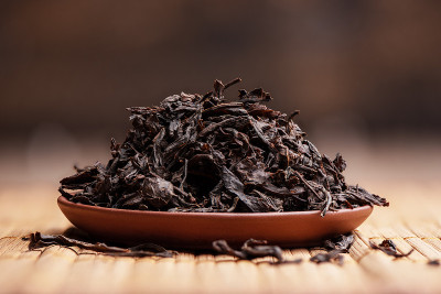 在垫子上的陶制茶碟上的干茶叶。