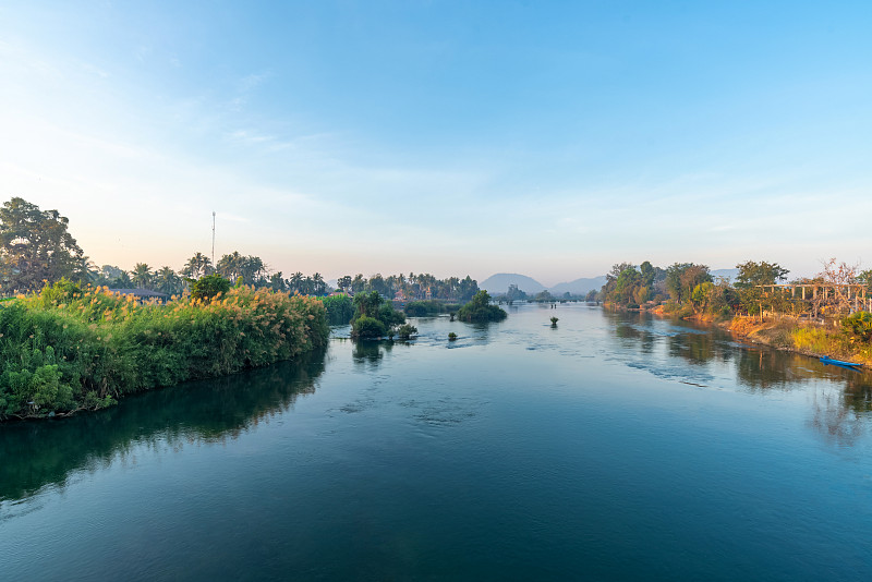 美丽的风景，日出和老木船下降近河从酒店前的登台，在虹吸岛，著名的游客放松的地方，老挝。