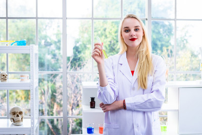 一个女性研究人员在化学实验室里进行研究的科学家拿着试管和样品在实验室分析的背景