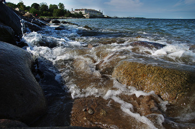 岩石和波浪的海岸与老建筑的背景