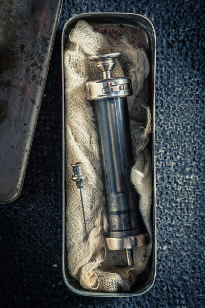 特写的旧注射器在一个不锈钢容器