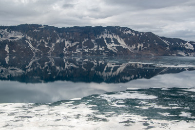 在冰岛的阿斯加火山口的高地上Öskjuvatn的水里的山脉的倒影。