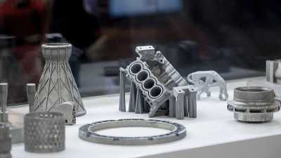 男人拿着用金属3d打印机打印出来的物体。