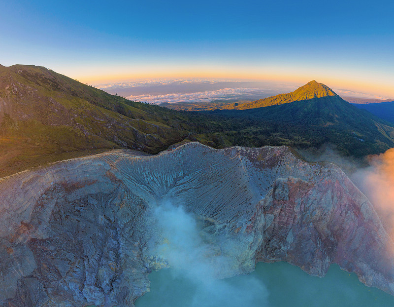 鸟瞰图的岩石悬崖在卡瓦伊真火山与绿松石硫水湖在日出。全景在东爪哇，印度尼西亚。自然景观背景。