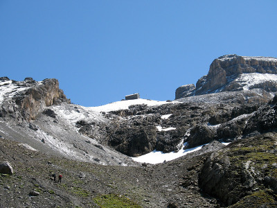 石山小屋坐落在高山上的岩石山谷中，在蓝天下