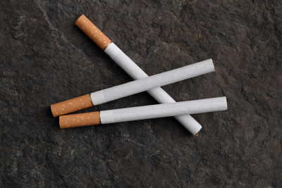 三支香烟在一块有纹理的灰色石头上。健康生活方式的概念。