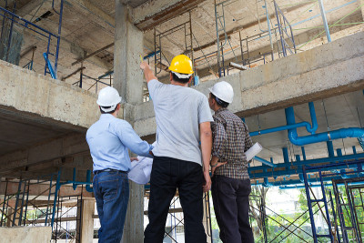 建筑概念，工程师和建筑师在施工现场与蓝图工作