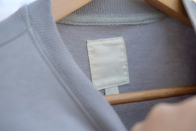 浅灰色毛衣样品上的服装标签