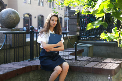 这个女孩坐在城市公园的长椅上