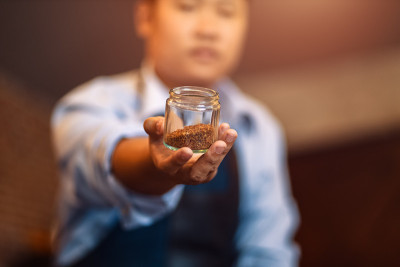 咖啡师展示滴漏杯里的咖啡豆。