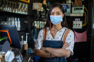 亚洲商人和咖啡师戴着面具和微笑后重新开业的咖啡店