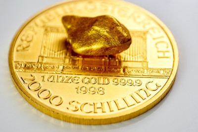 黄金奥地利爱乐一盎司硬币铺在一堆金块上，黄金矿石
