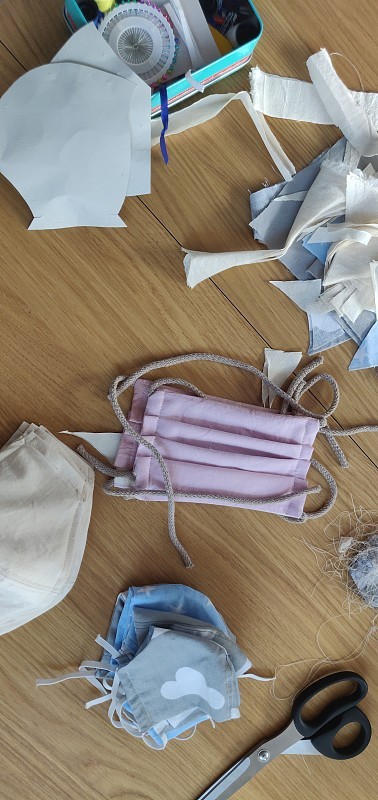 Self-sewing防护面具。桌上放自制的防护口罩和几块布