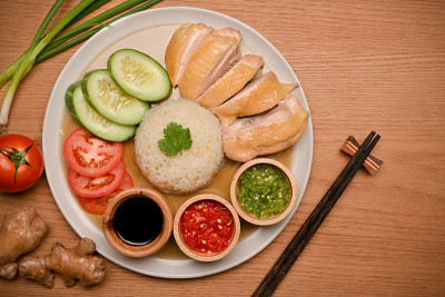 美味的海南鸡饭放在木桌上的盘子里。俯视图