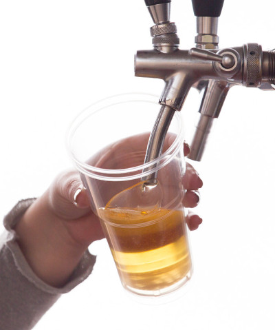 酒保把啤酒倒进塑料玻璃杯