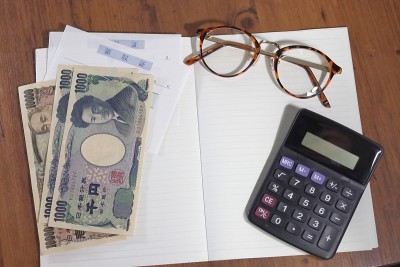 钱，收据，笔记本和杯子都放在桌上