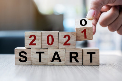 商人手持木质立方体翻转块2020至2021年开始字在桌子的背景。决议，策略，解决方案，目标，业务和新