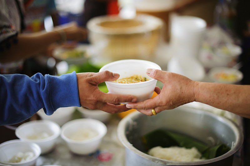 富人的手给穷人的手食物:食物帮助贫困的社会问题:概念生活的问题穷人:分享的概念