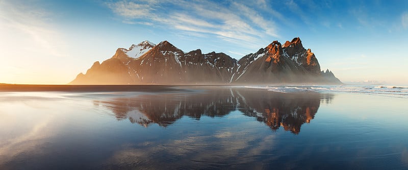 冰岛东南部Stokksnes海角的黑沙滩，有Vestrahorn(蝙蝠侠山)。色彩缤纷的夏日早晨，欧