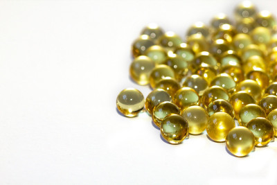 黄色鱼油胶囊，白色背景。Omega3型维生素特写。胶囊鱼油宏。维生素对健康。