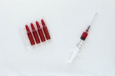 白色背景上的安瓿和注射用维生素B组的注射器桶的俯视图