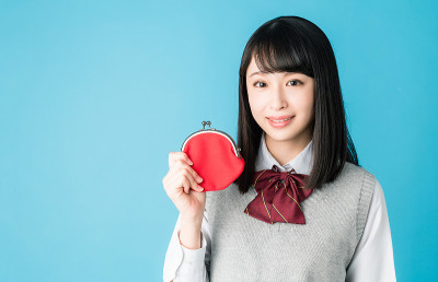 亚洲女学生拿着一个硬币钱包。