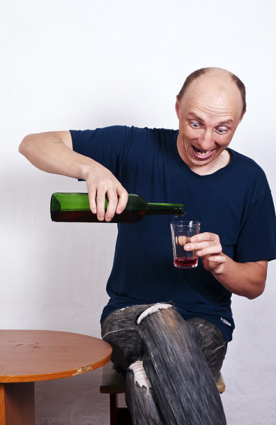 往玻璃杯里倒酒的人