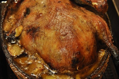鸭肉配苹果和蔓越莓。用砂锅烤的家禽。