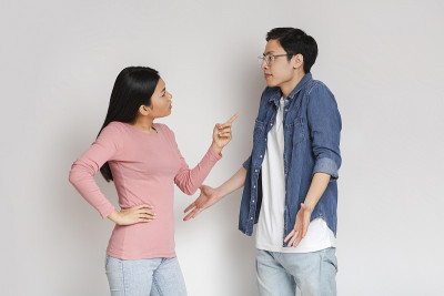 亚洲愤怒的女孩责骂她惊讶的男朋友