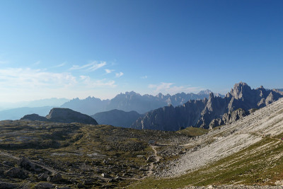 意大利Dolomites的一个巨大的山谷。山谷的两边都是高耸的山峰。早晨的阳光使山谷温暖起来。偏僻偏