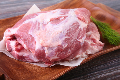 生猪肉排放在木板上，配上香草、大蒜和香料准备烹调。有选择性的重点。
