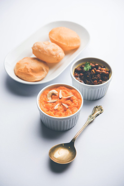 Suji/Sooji Halwa Puri或Shira Poori配黑色查纳马沙拉早餐，盛在盘子和碗