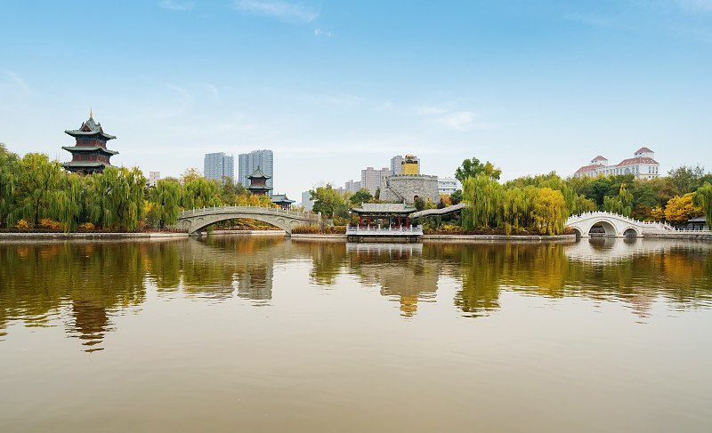 秋天，中国山西省太原市迎泽公园里有古建筑和拱桥