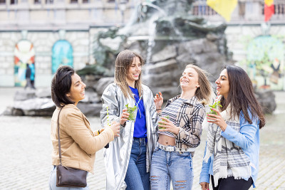生活方式户外组的多民族美丽的年轻女性碰杯庆祝生活，爱，幸福，友谊在夏季的城市户外。