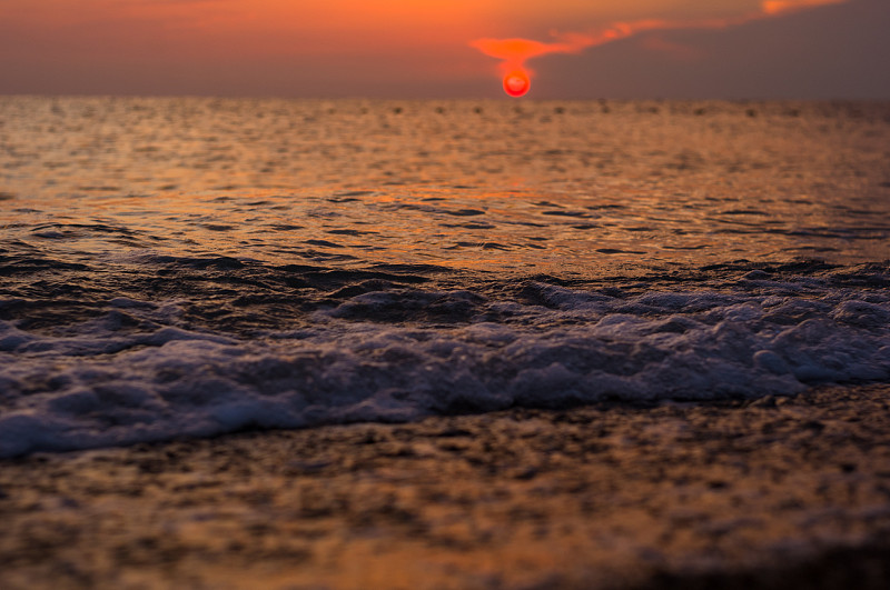 卵石滩上惊人的海上日落，太阳，海浪，云彩