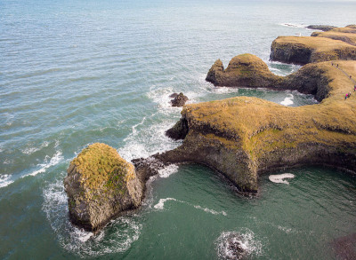 冰岛斯奈费尔斯半岛西海岸悬崖的长曝光照片。湛蓝的海水，海面上有高高的峭壁。美丽多彩的玄武岩礁风景。