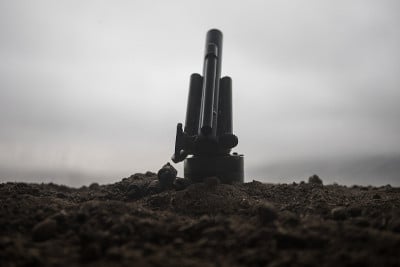 战斗场景。老野战炮的剪影站在战场上准备开火。有彩色的深色雾背景。有选择性的重点