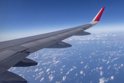 从窗口看飞机机翼，美丽的天空。旅游的概念
