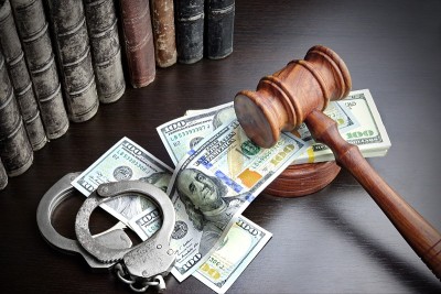 法官的木槌，手铐，现金和书在黑色的桌子上
