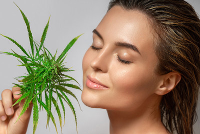 CBD cosmetics concept. Beautiful woman with a cann