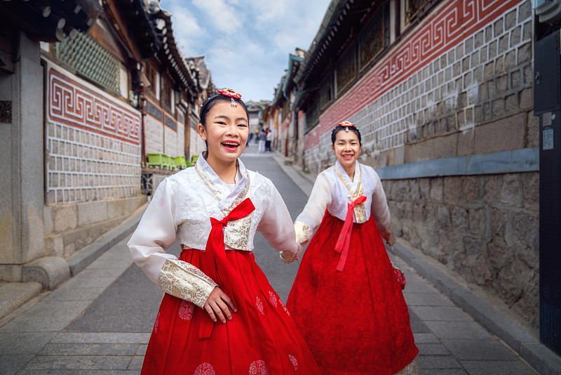 一位穿着韩服的韩国女士漫步在一座古城和景福宫