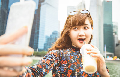 美丽的亚洲女人漫步在现代城市的滨海湾在日落新加坡天际线自拍-冒险旅行的生活方式东南亚首都城市-明亮温