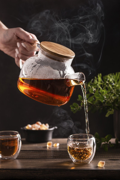 木桌上放着黑热茶和糖棒棒糖