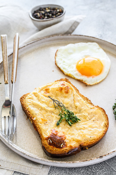 Croque Monsieur是一款传统法式烤奶酪火腿三明治，配白汁。白色背景。俯视图