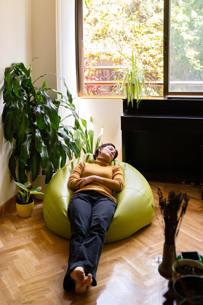 一个孤立的女人在客厅打盹的垂直视图。