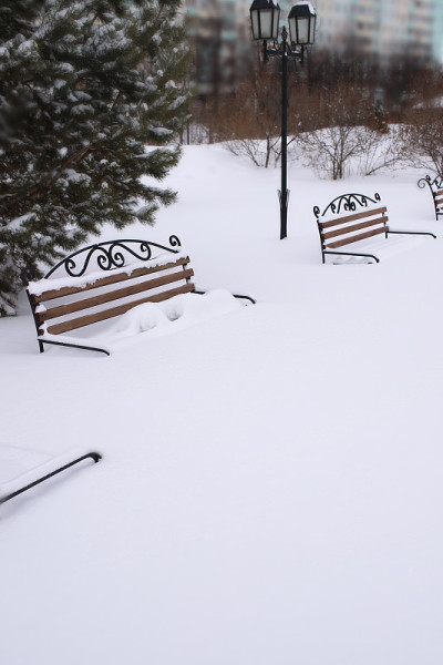 一场暴风雪过后，白雪覆盖的镂空长凳