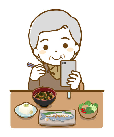用餐时使用智能手机的老人