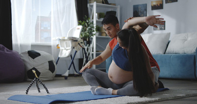 年轻男子指导孕妇健身
