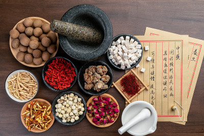 桌上放着古老的中医书籍和药草